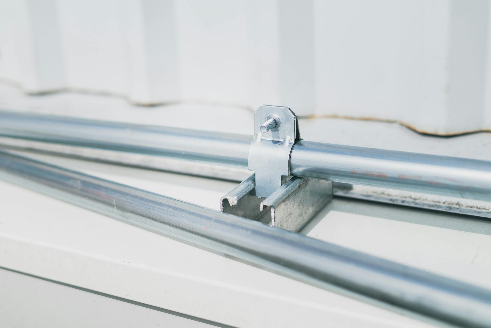 Detailed close-up of a metal pipe clamp on a stainless steel surface, highlighting industrial design.